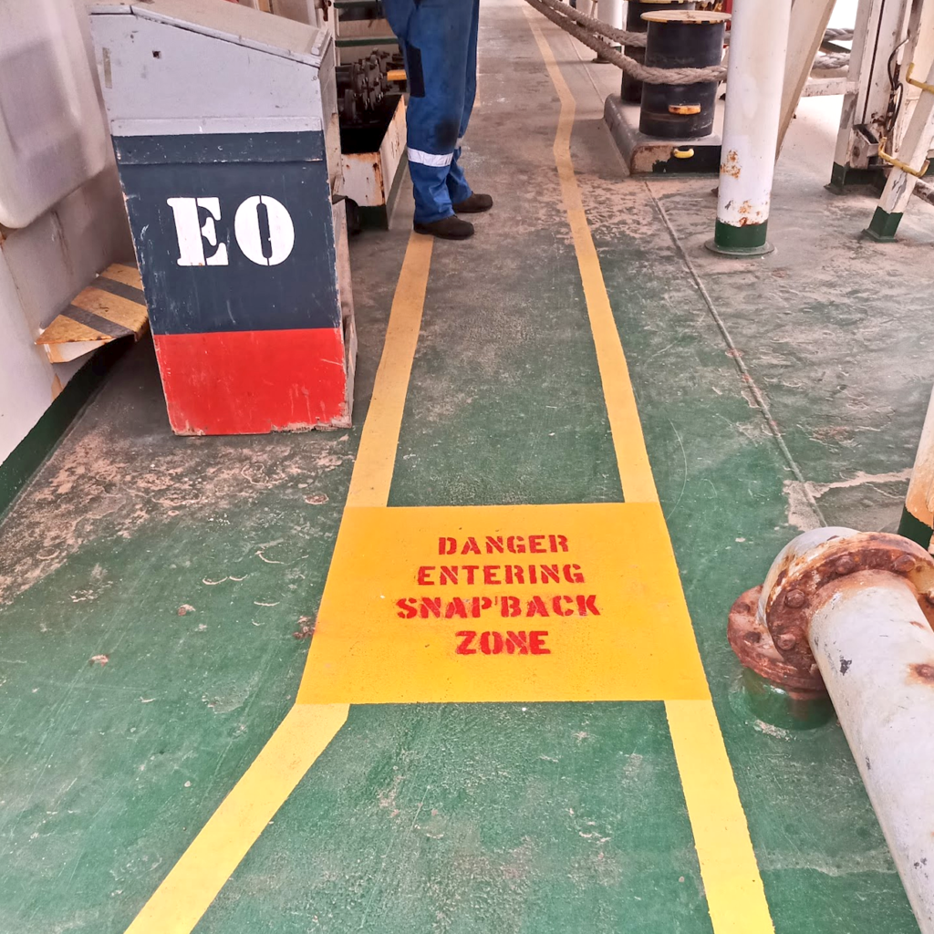 a man standing on a yellow sign on a green surface ship